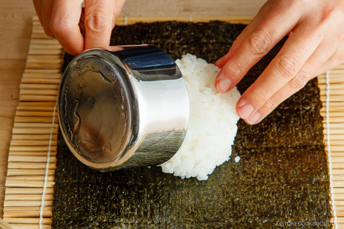 Transfer sushi rice to a sheet of nori placed on the bamboo mat.