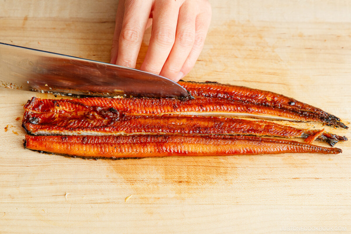 Cutting unagi into strips.