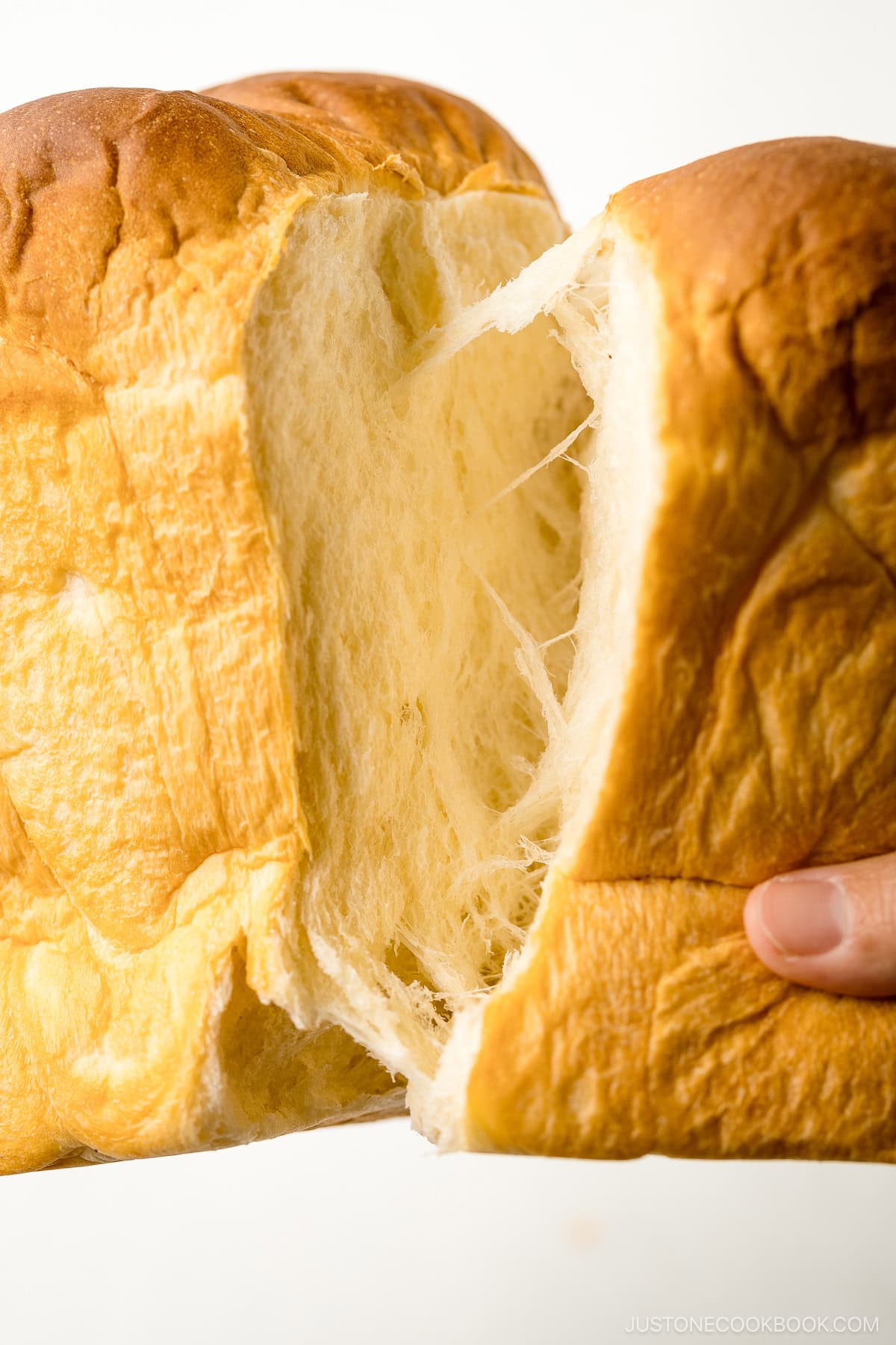 Japanese milk bread (shokupan) being torn apart with hands.