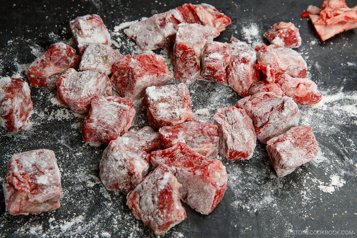 Coating the beef with flour.