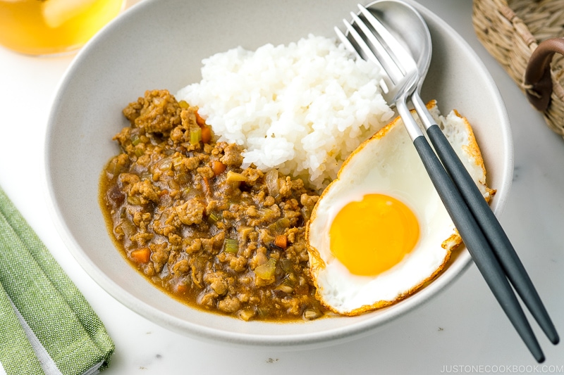 A bowl containing Keema Curry, steamed rice, and a fried egg.