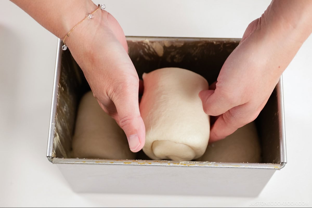 Placing the rolled dough in the pan.