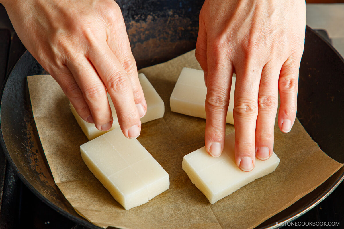 Gently press down the mochi for equal browning.