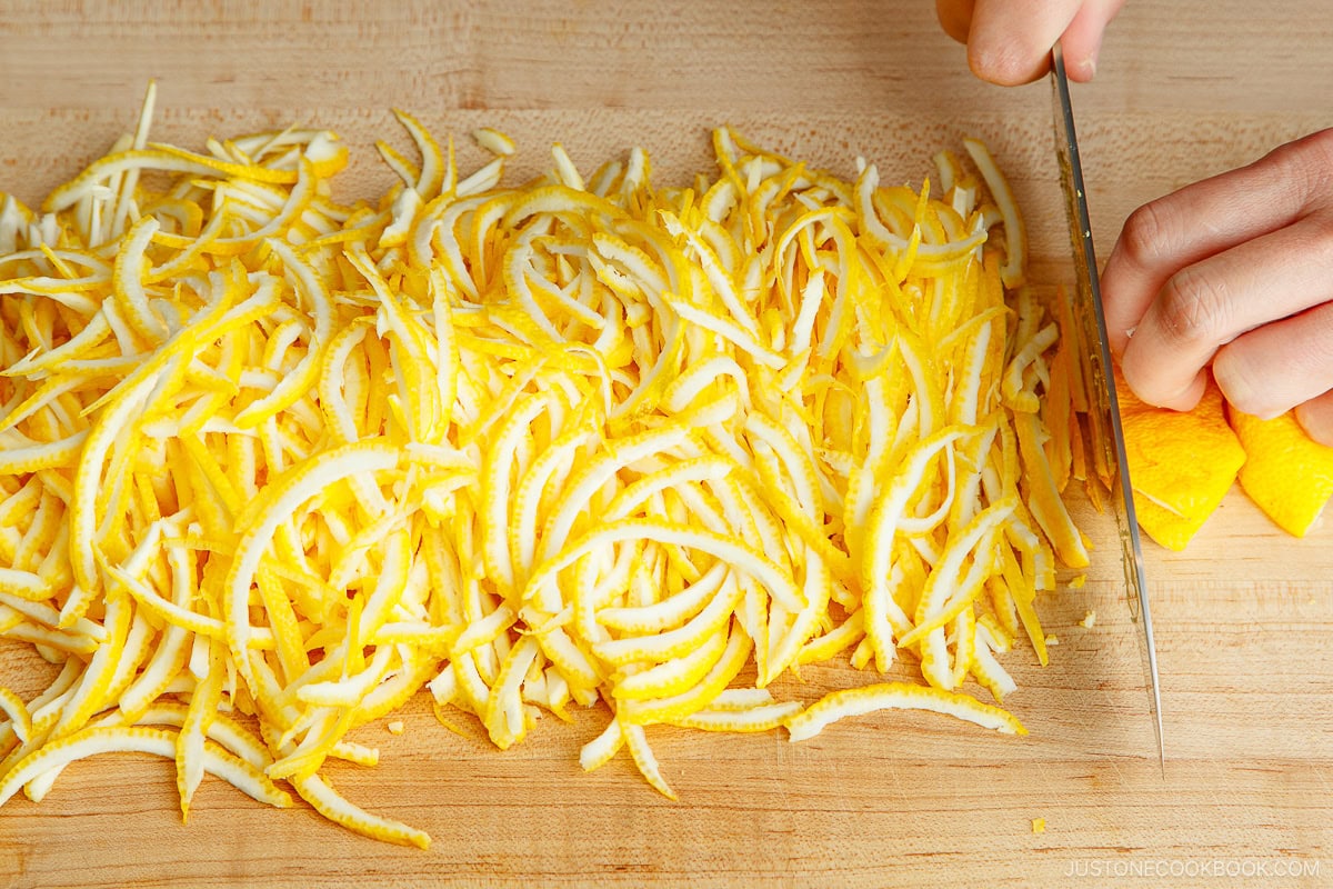 Cutting yuzu peel into thin julienne strips.
