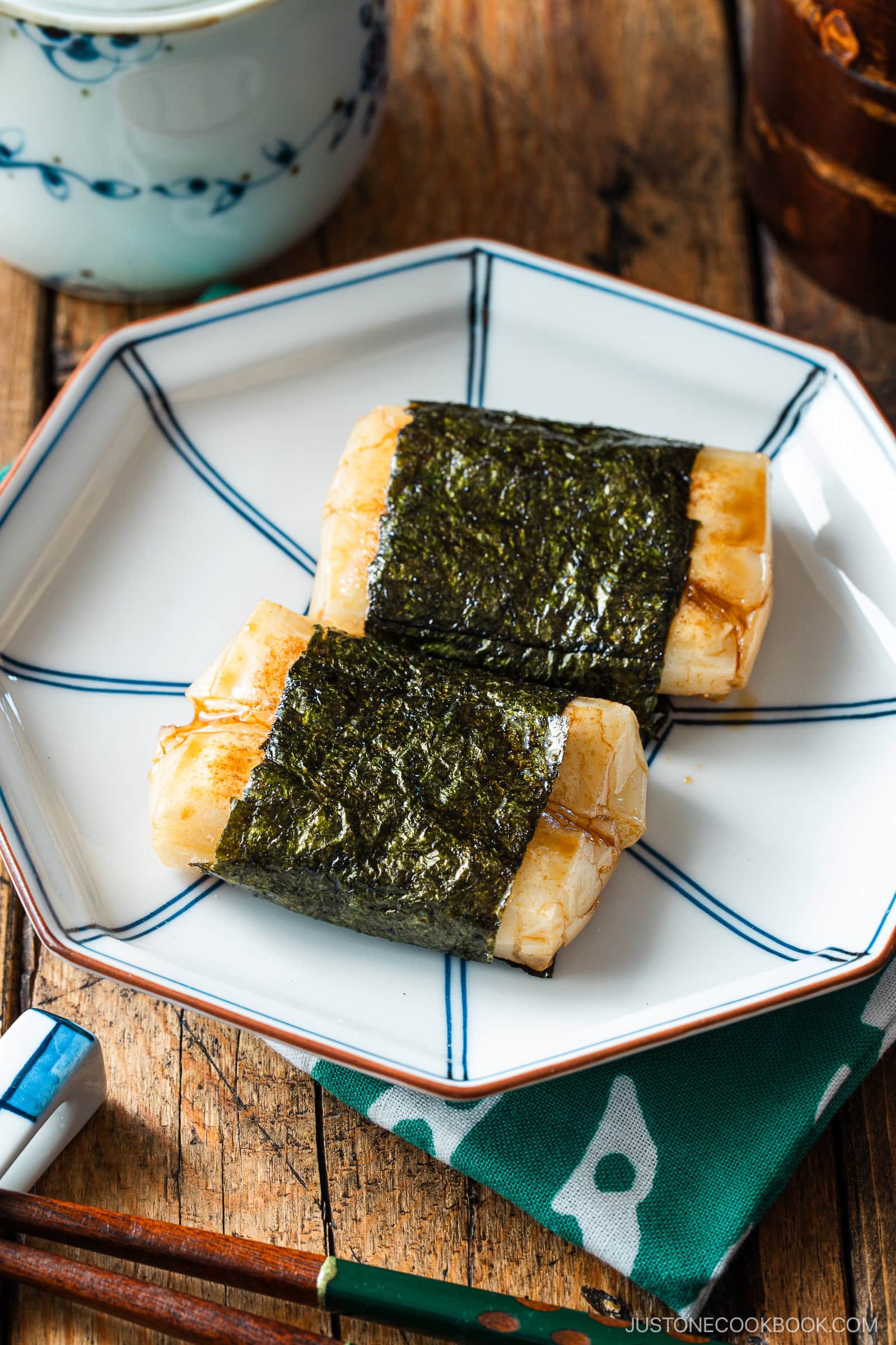 An octagon blue plate containing cheese-stuffed Isobeyaki Mochi wrapped with nori seaweed.
