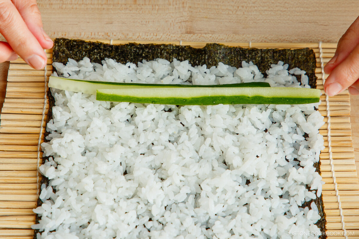Place the cucumber sticks on the rice.