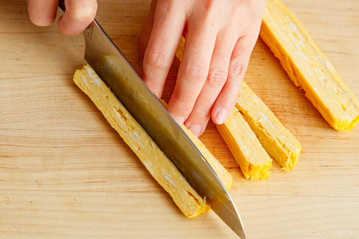 Cutting tamagoyaki into sticks.