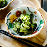 Small Japanese bowls containing Japanese cucumber salad called Sunomono.