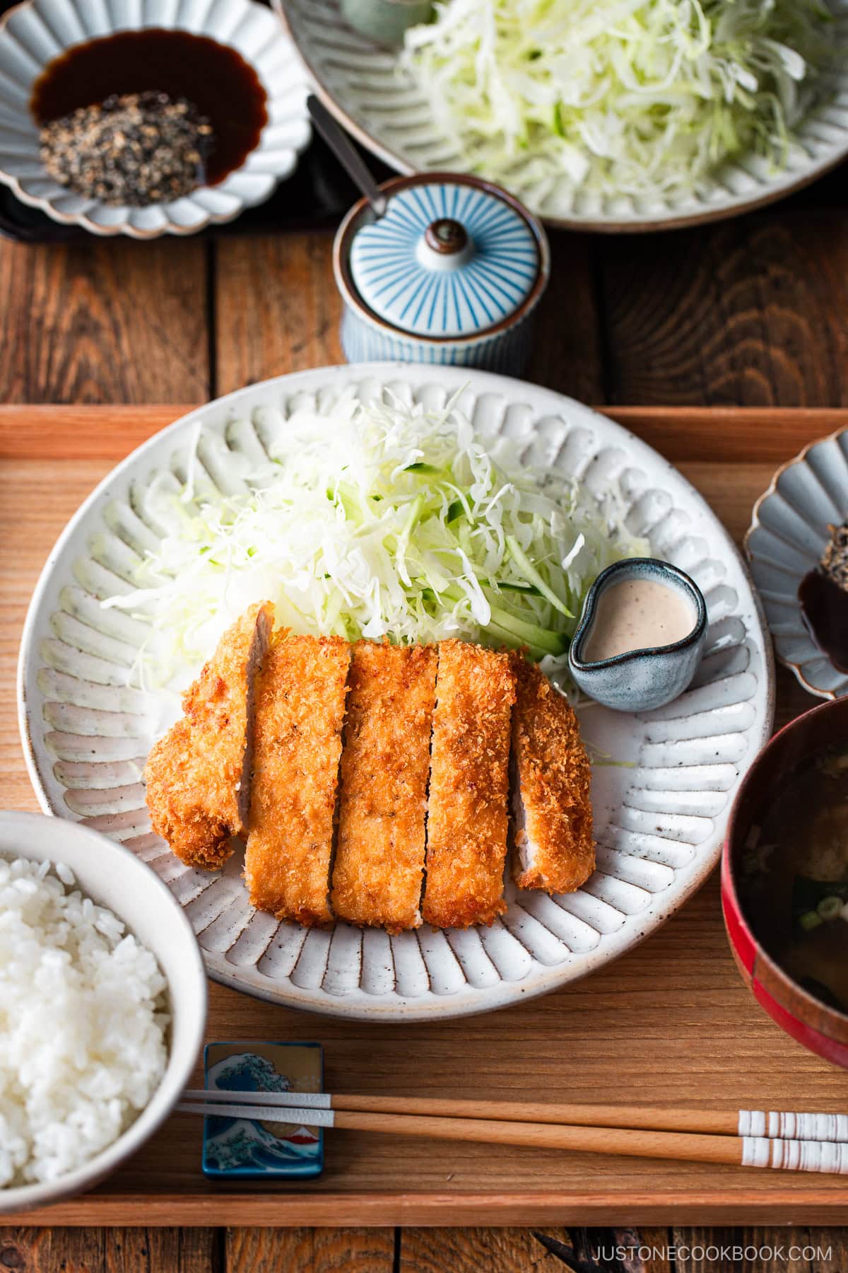 Japanese ceramic plates containing Tonkatsu (pork cutlet) and shredded cabbage salad.