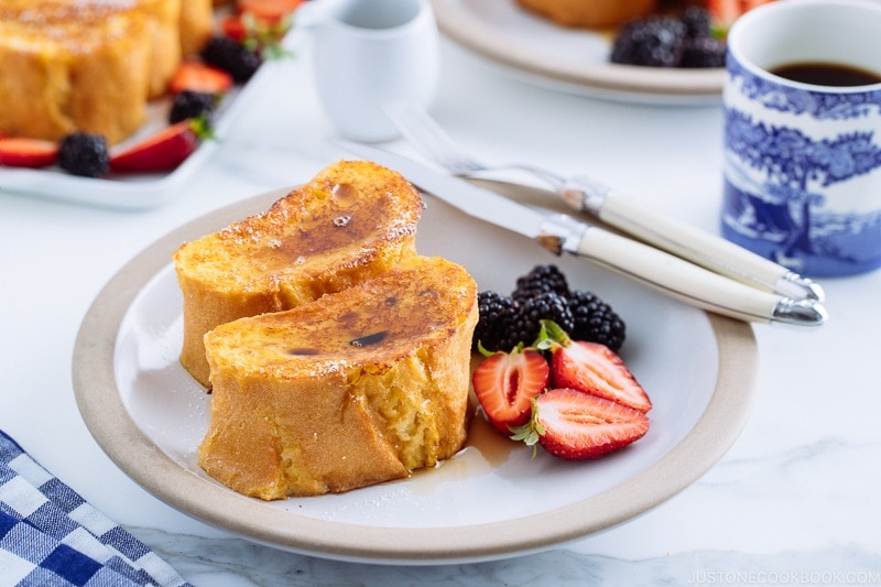 A plate containing French toast, strawberries, and blackberries.