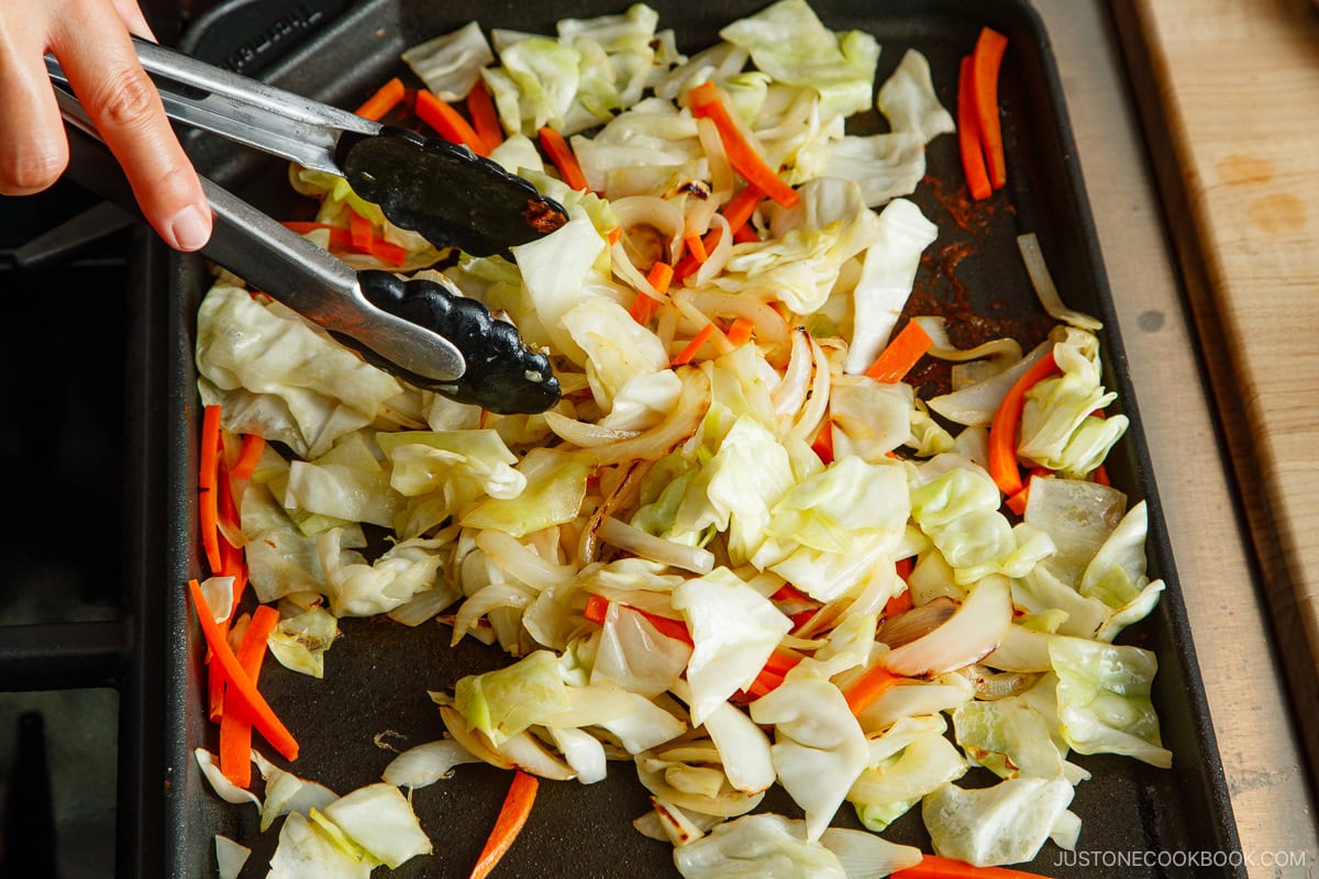 Stir fry the vegetables on the griddle.