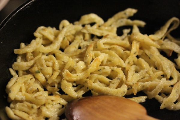 Buttered späzle browning in a skillet.