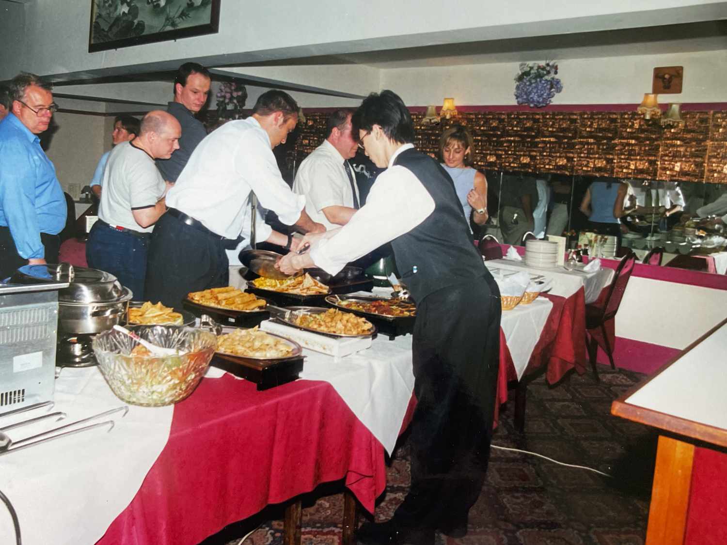 People standing around a British Chinese buffet table