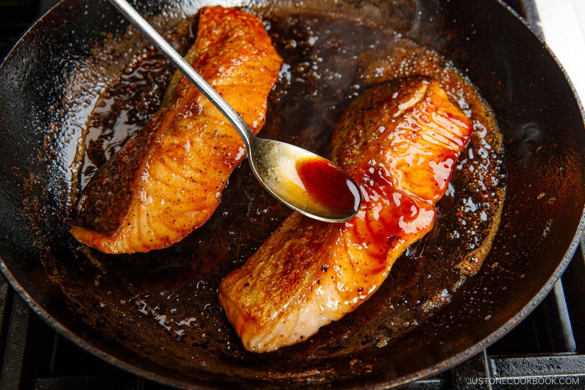 Spooning the sauce over the salmon.