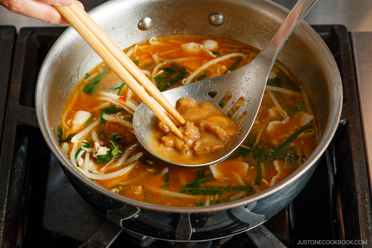 Dissolving the miso paste in the ladle.