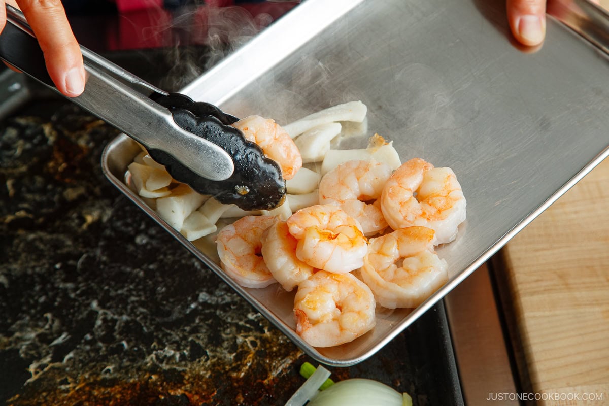 Removing seafood from the griddle.
