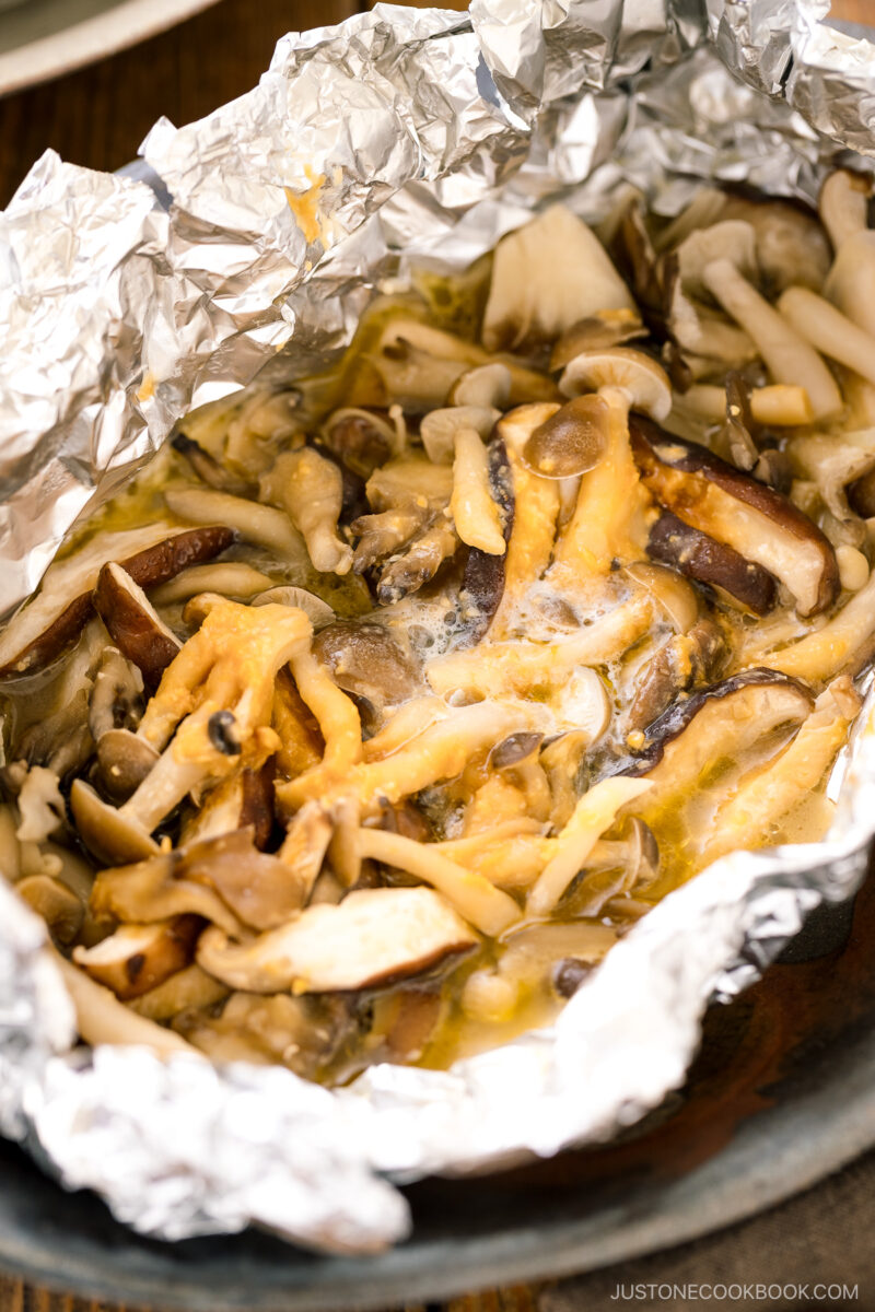 Assortment of mushrooms are wrapped and cooked in foil with miso and butter.