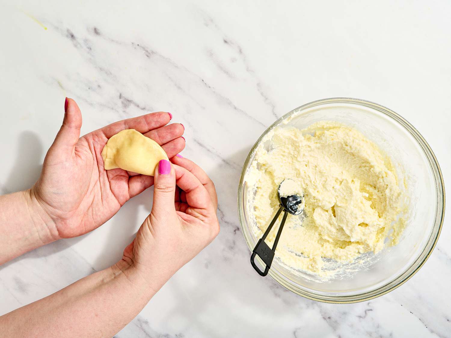 Pinching edges of dumpling with fingers 