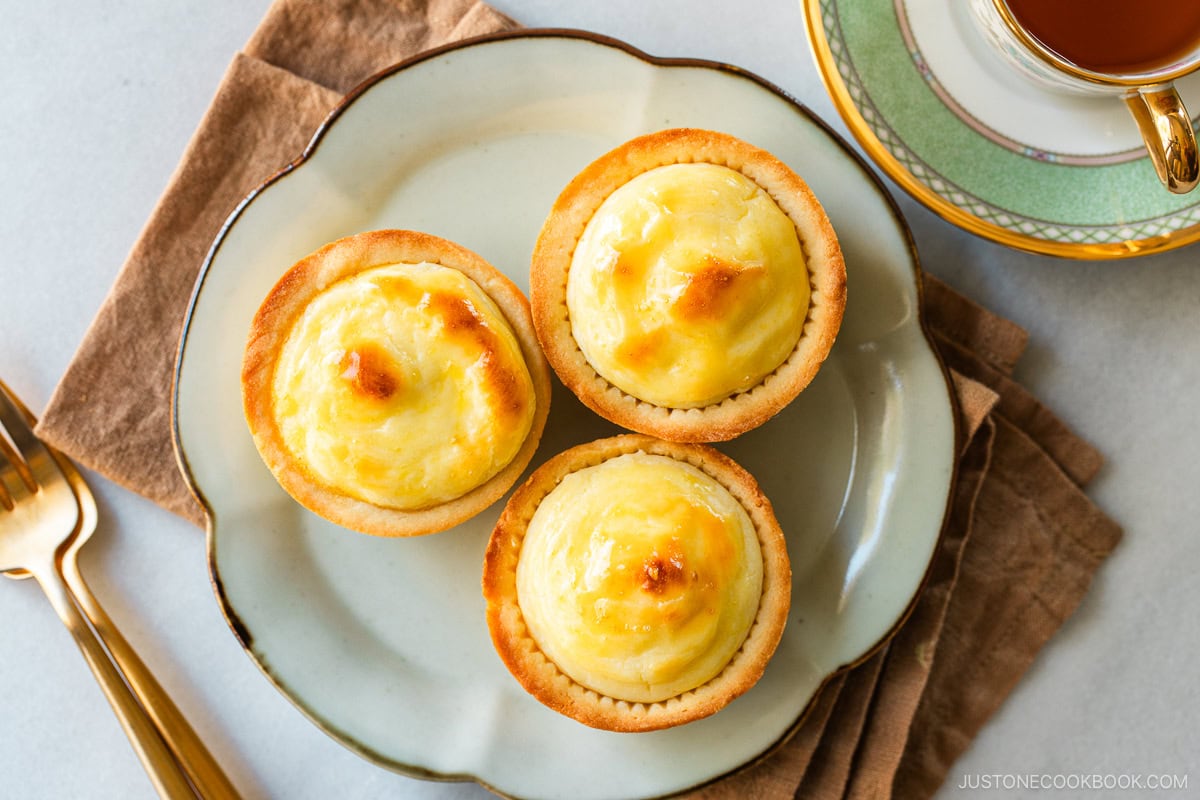 A flower shaped-plate containing baked cheese tarts.