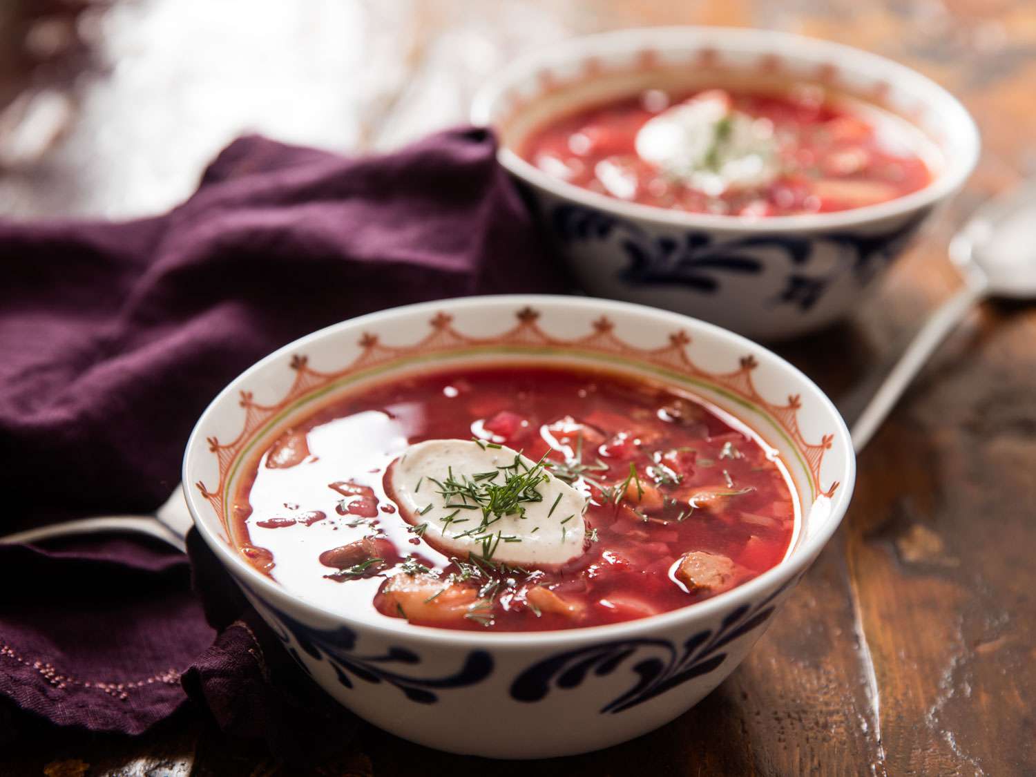 Bowls of Ukrainian borscht topped with sour cream and dill.