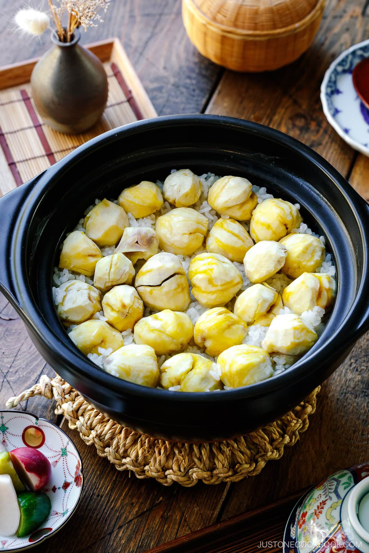 A ceramic donabe pot containing Japanese chestnut rice (kuri gohan); peeled chestnuts beautifully laying over steamed rice in a single layer.