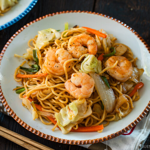 Round plates containing shrimp yakisoba.