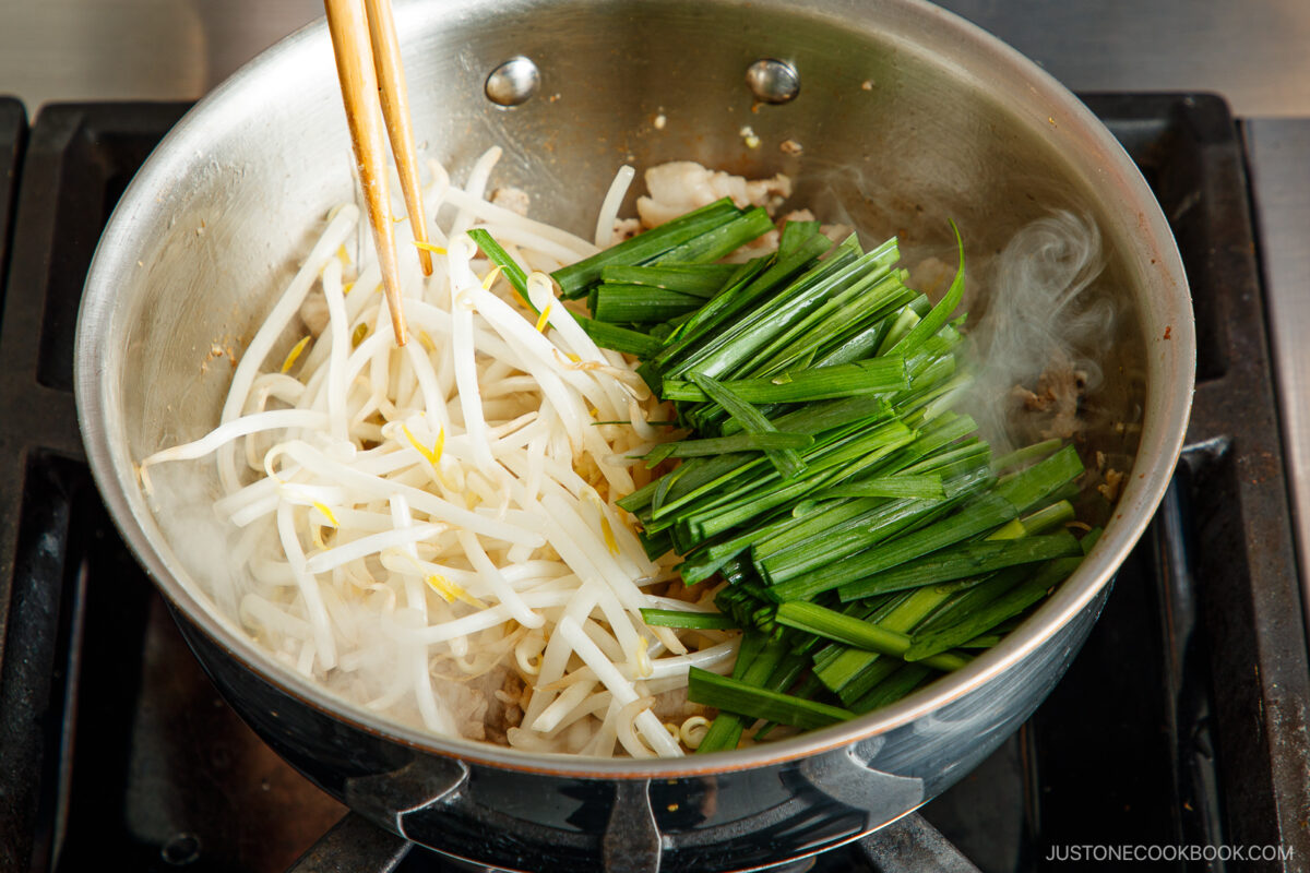 Adding the bean sprouts and garlic chives.