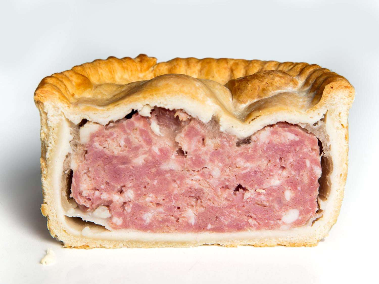 Interior of a Yorkshire pie, with a pink, hamlike meat filling and straight pastry sides