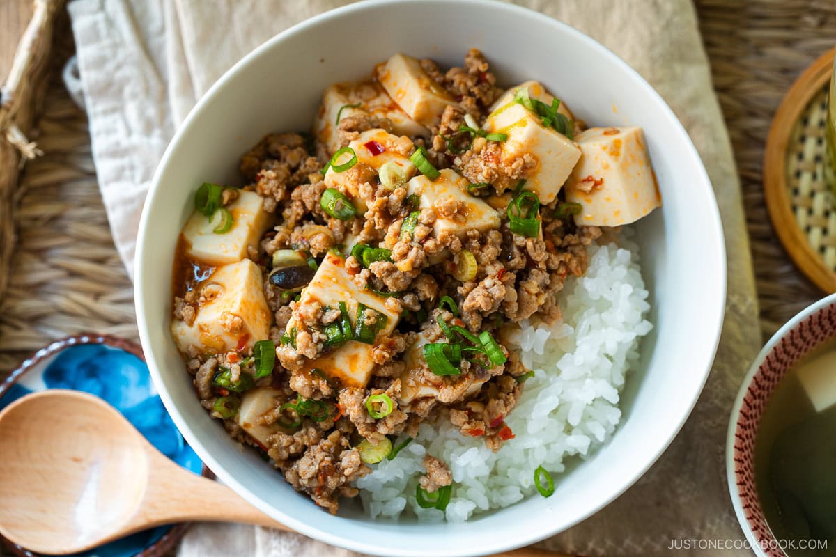 A donburi bowl containing mapo tofu over bed of steamed rice.