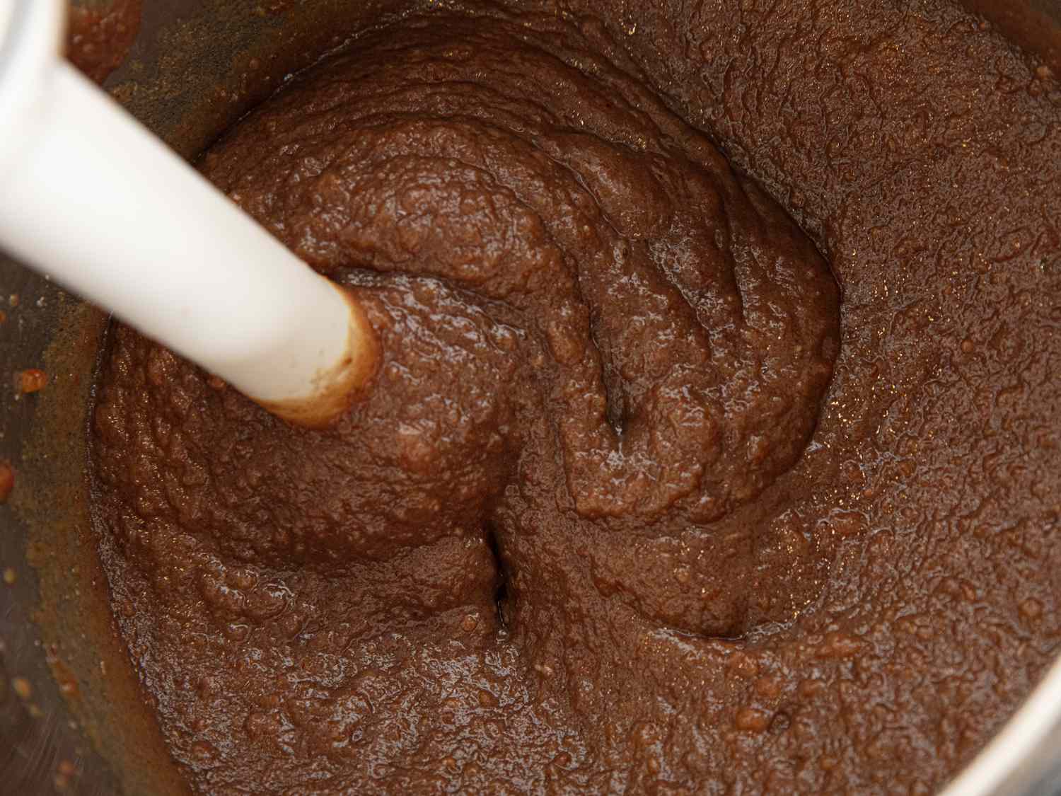 Overhead view of using an immersion blender on prune mixture