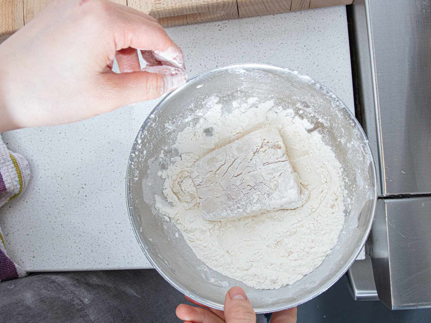 Overhead view of adding fish to flour