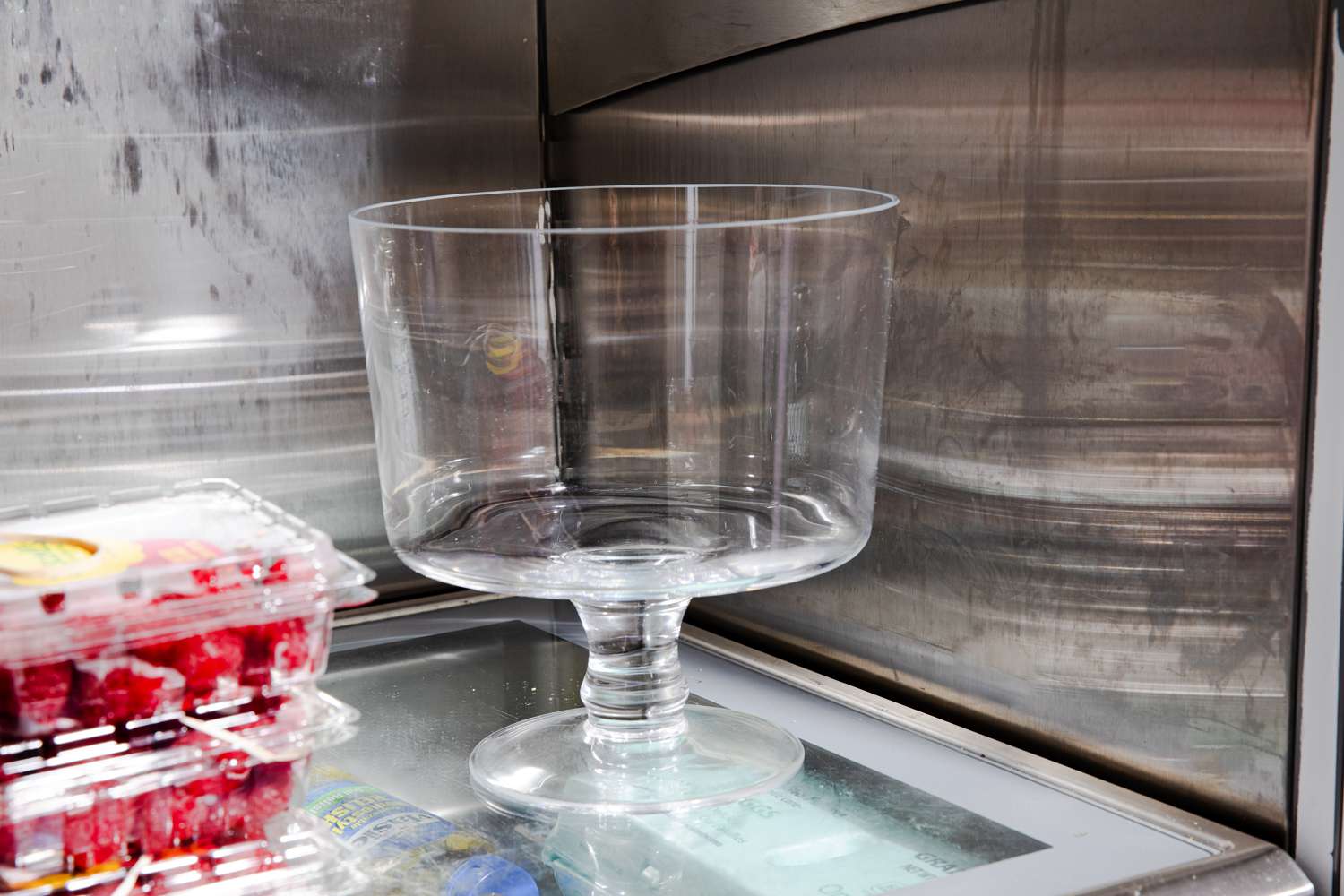 A trifle bowl chilling in a fridge