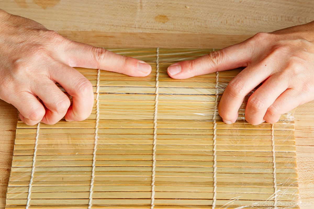 Cover the sushi with bamboo wrap.