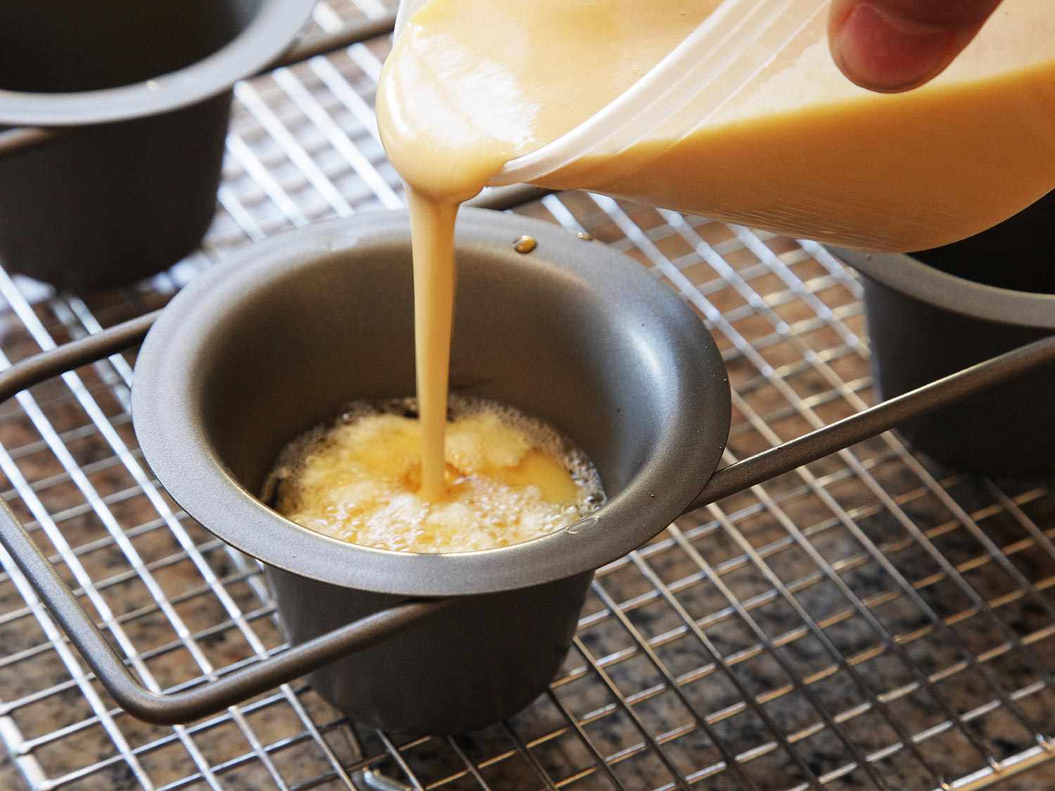 Yorkshire pudding batter being poured into popover tin on wire rack