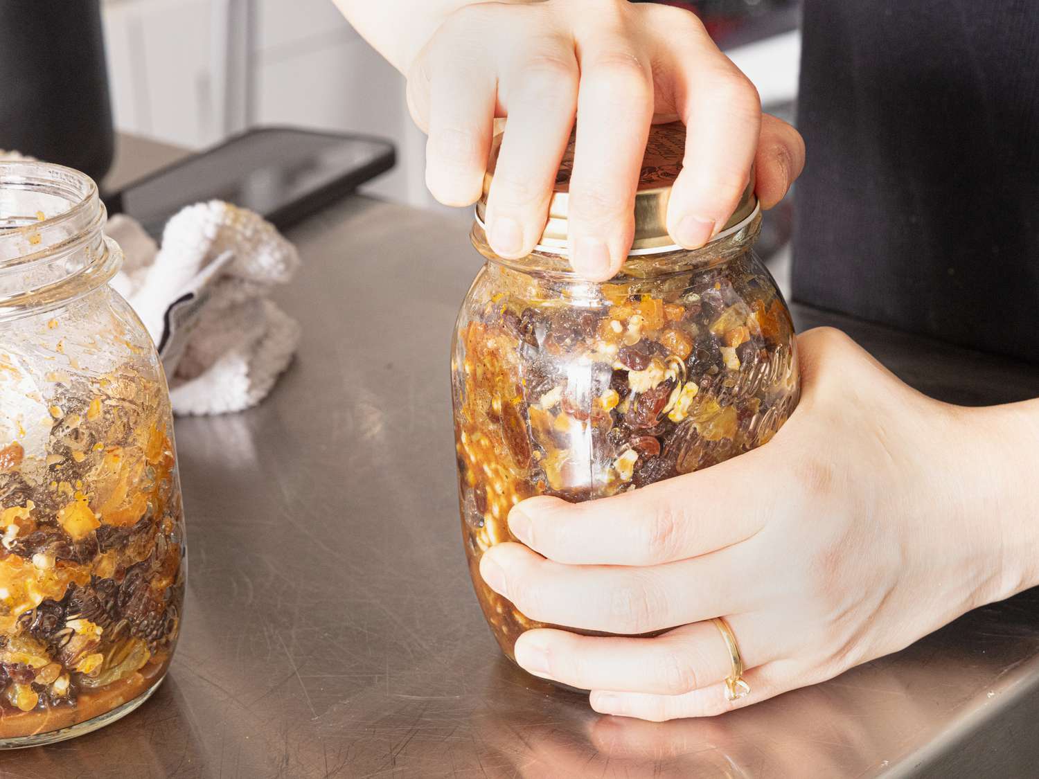 Closing lid of mason jar with mincemeat filling in it 