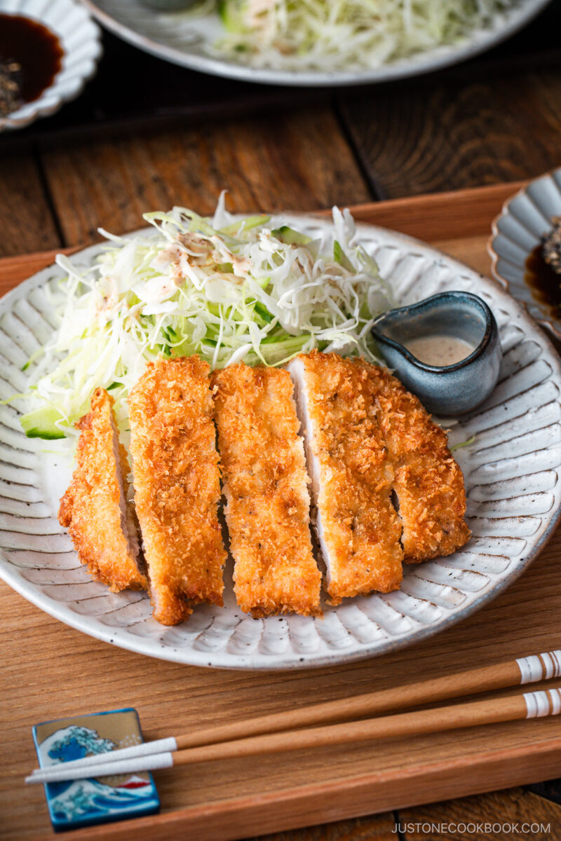 Japanese ceramic plates containing Tonkatsu (pork cutlet) and shredded cabbage salad.