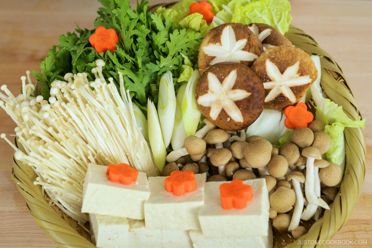 Bamboo basket filled with veggies, mushrooms, and tofu.