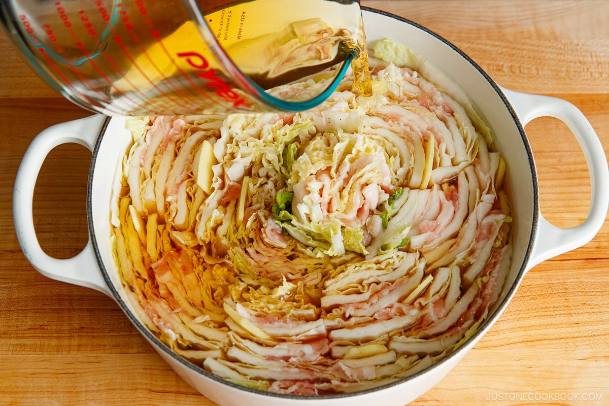 Insert the ginger slices between the cabbage and pour the broth on top.