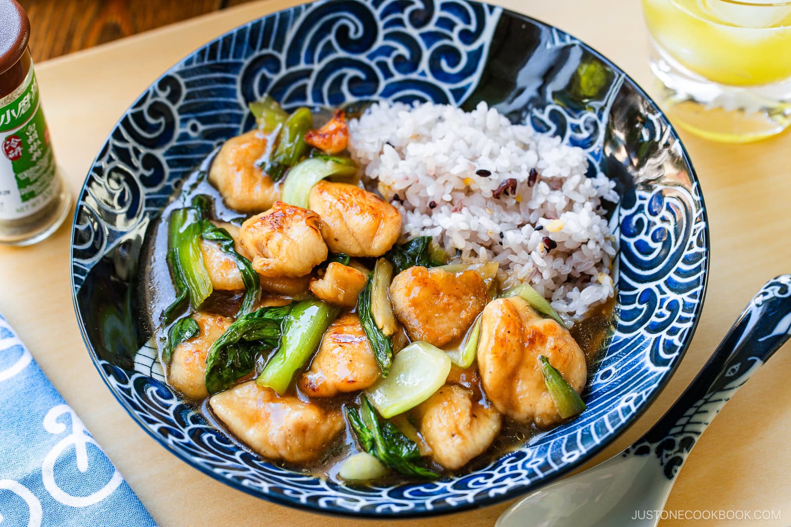 A large shallow bowl containing multi-grain rice and Chicken Bok Choy Stir Fry.