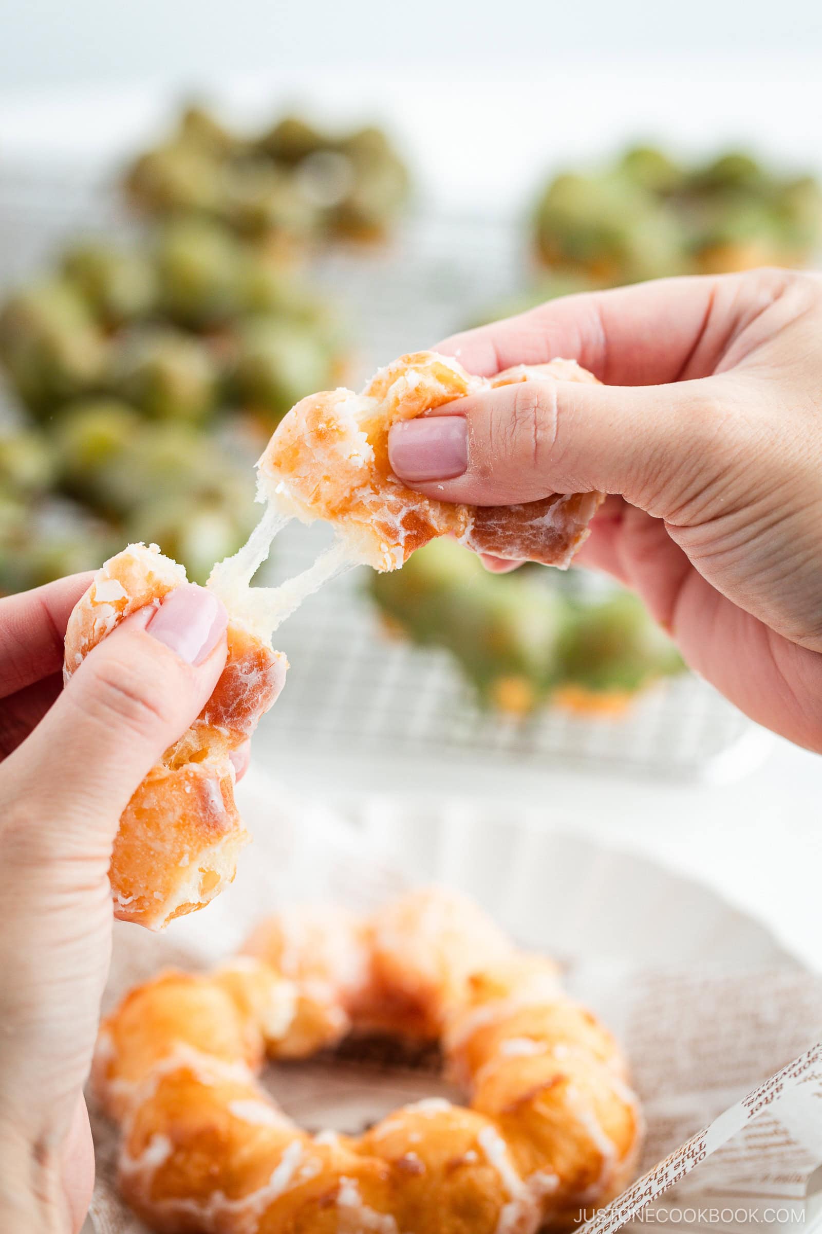 Warm, glistening Pon de Ring donuts—freshly fried and coated in sugar and matcha glaze—pulled apart with sticky fingers.