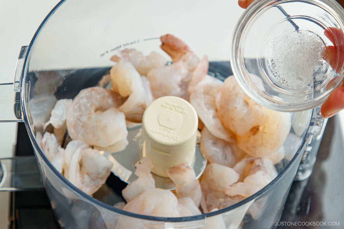 Adding the shrimp and salt in the food processor.