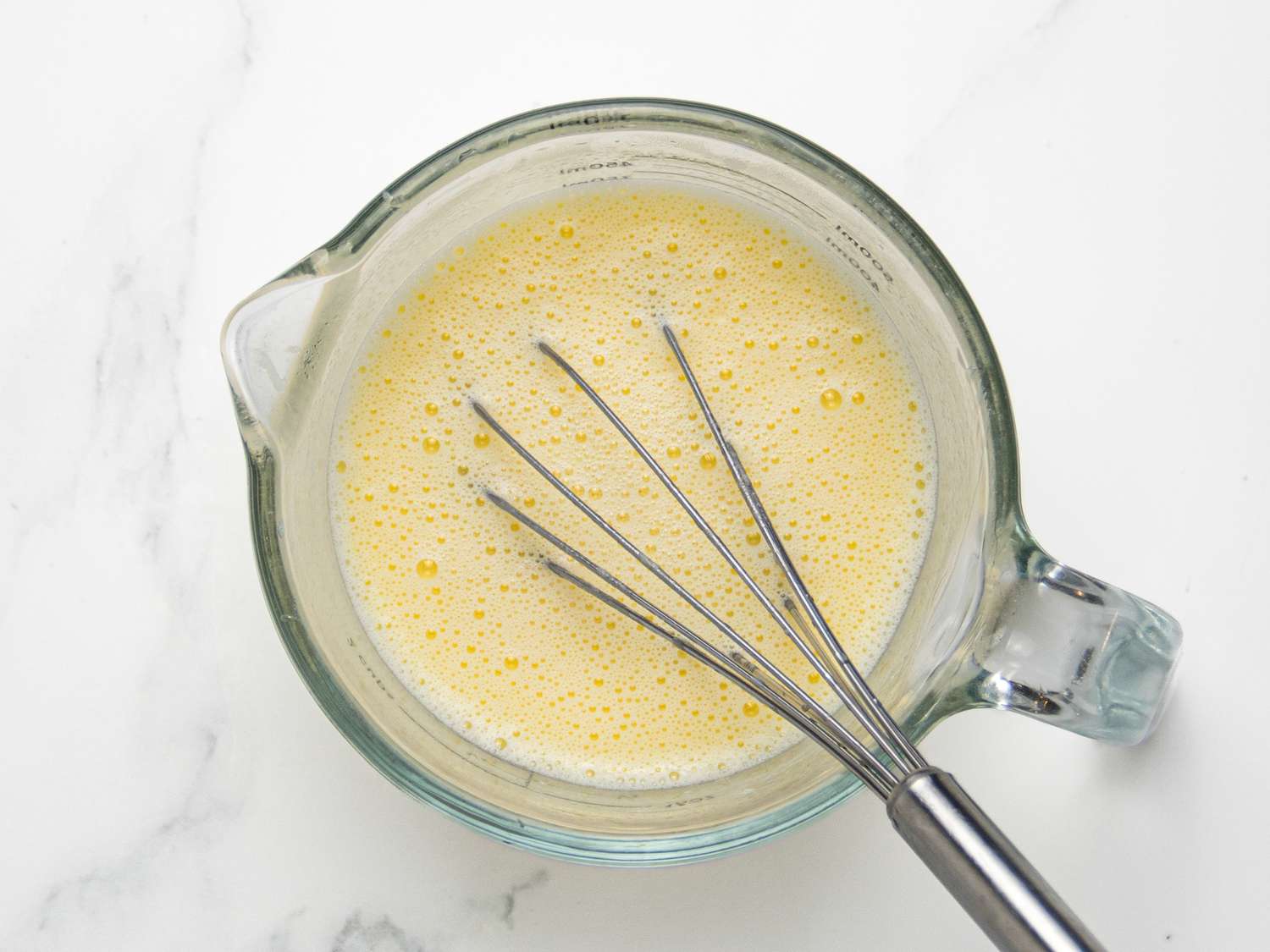 Whisking liquid ingredients together in measuring up 
