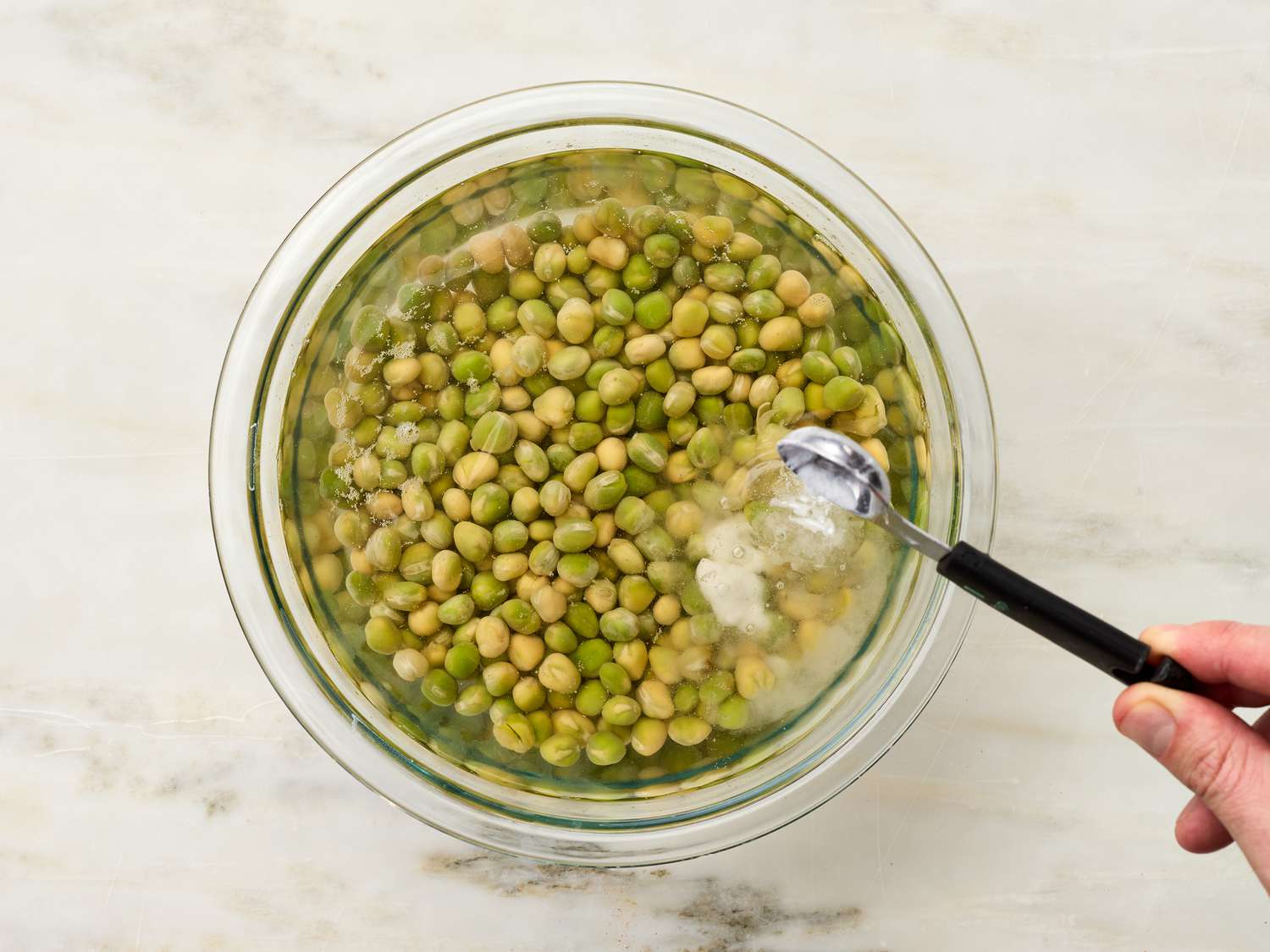 Soaking peas in a bowl with baking powder 