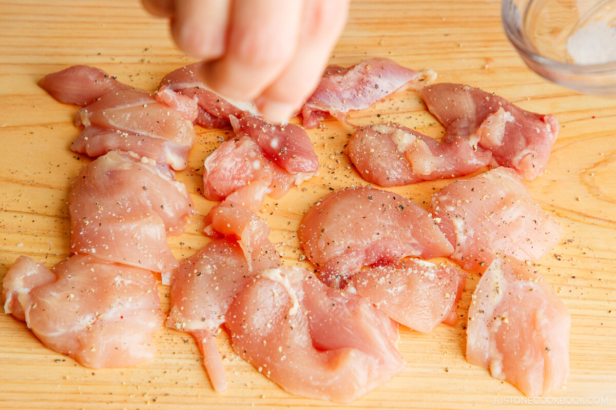 Cut the chicken thigh into small pieces and season with salt and pepper.