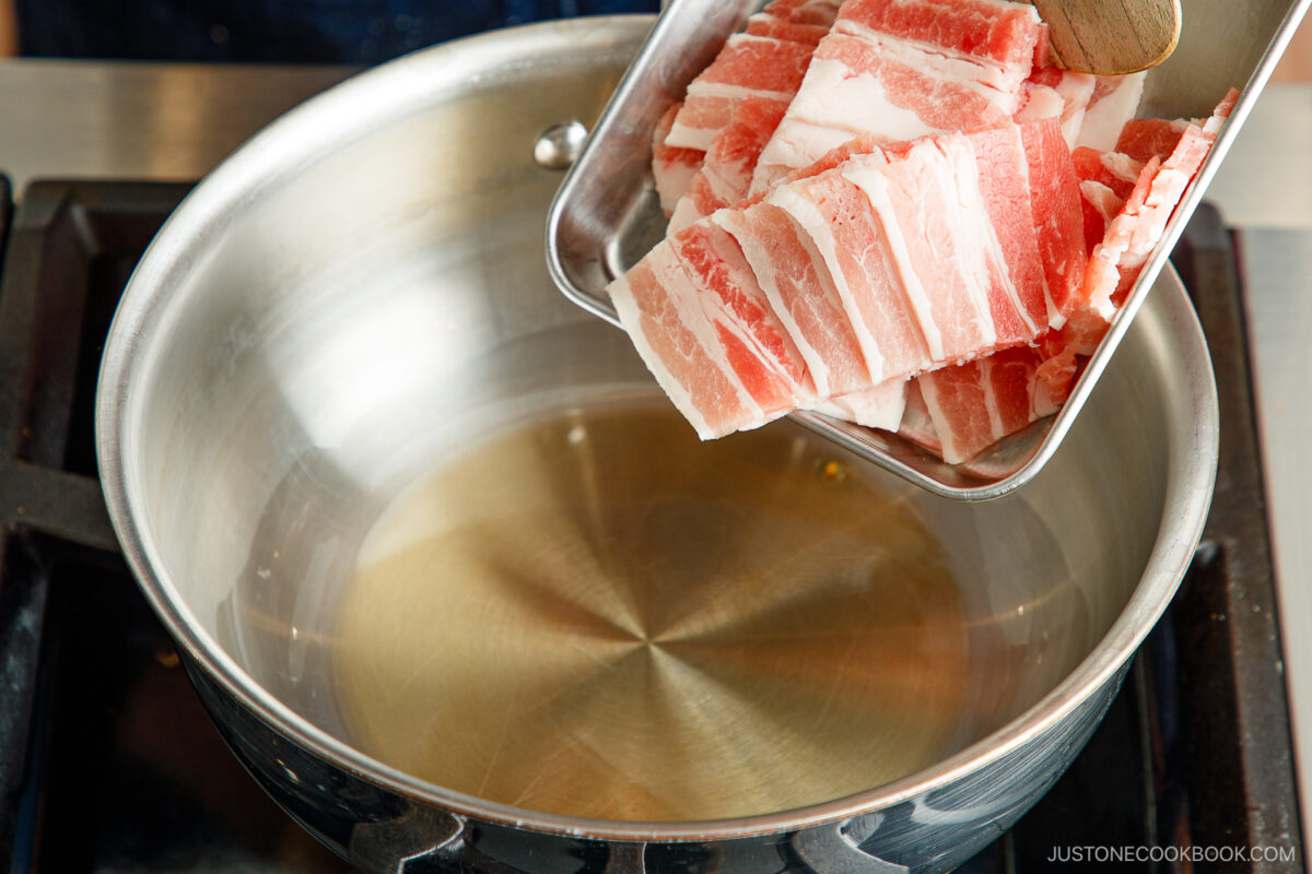 Add the pork belly slices to the hot sesame oil.