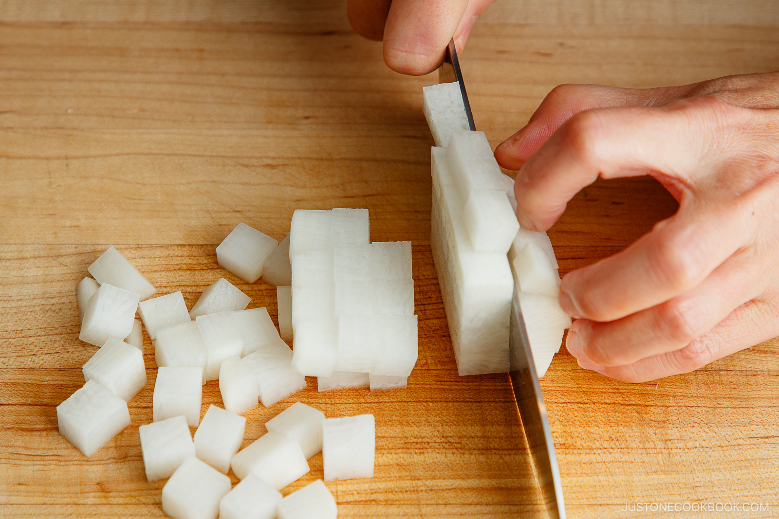 Cutting daikon into small cubes.