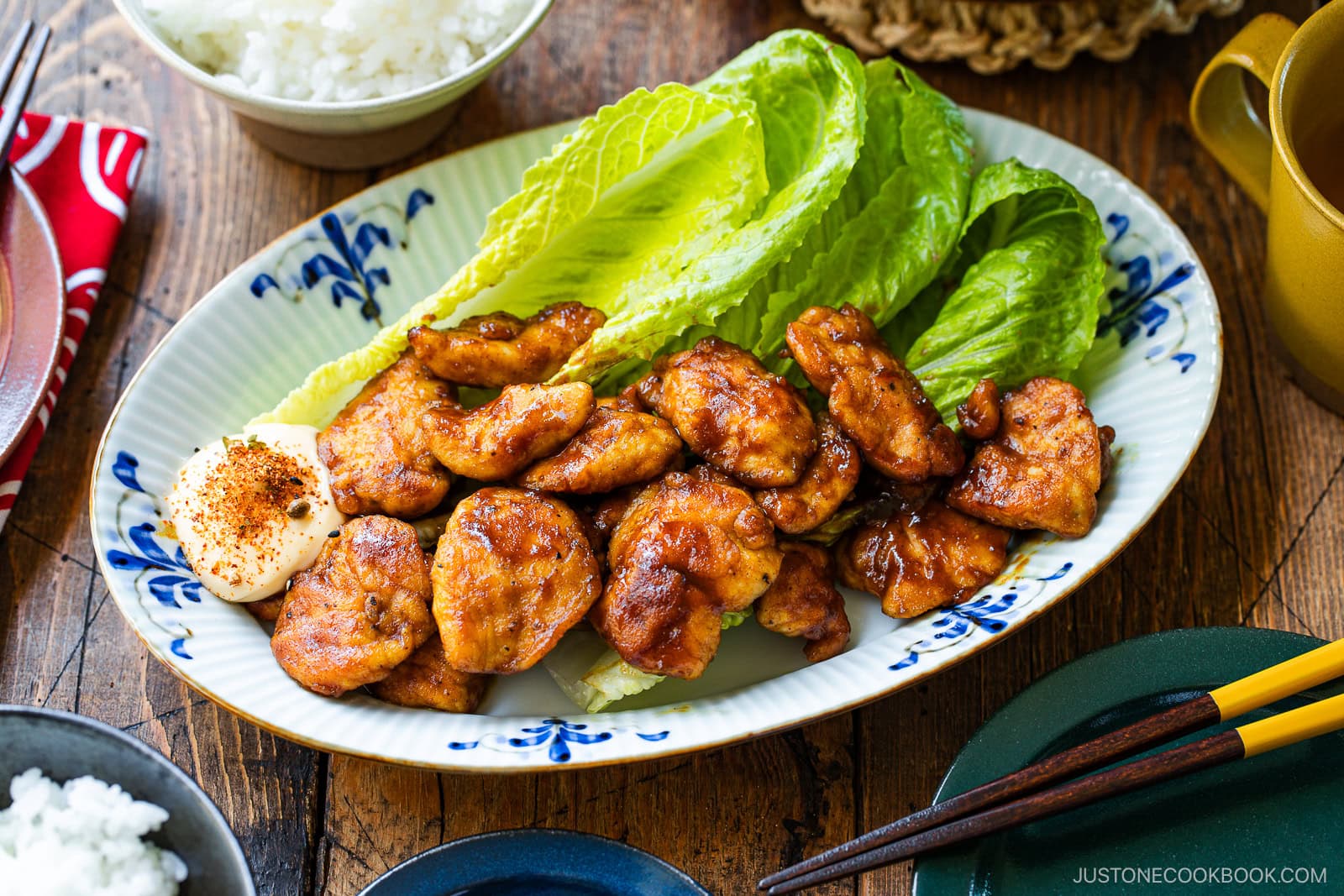 An oval shape plate containing Pan-Fried Curry Chicken garnished with lettuce.