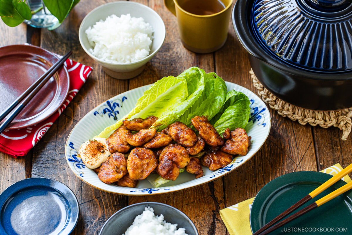 An oval shape plate containing Pan-Fried Curry Chicken garnished with lettuce.