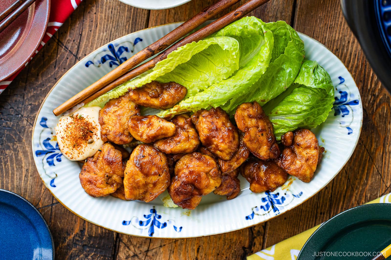 An oval shape plate containing Pan-Fried Curry Chicken garnished with lettuce.