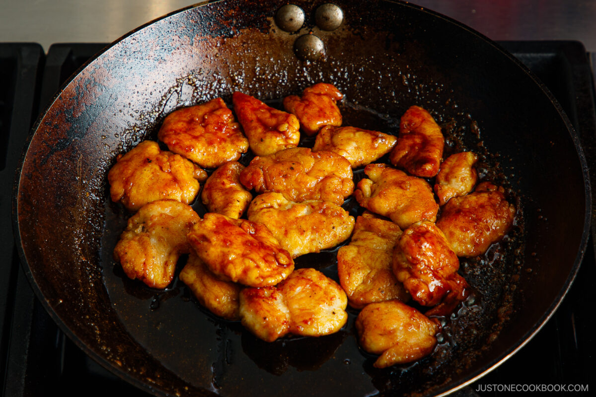 Coating the chicken with the sauce.